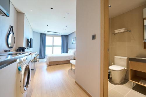 a hotel room with a bed and a bathroom at Chestertons Sokcho in Sokcho
