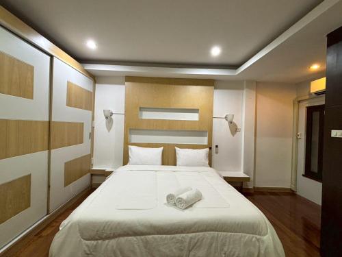 a bedroom with a large bed with two towels on it at Anchan Home Stay Hatyai in Hat Yai