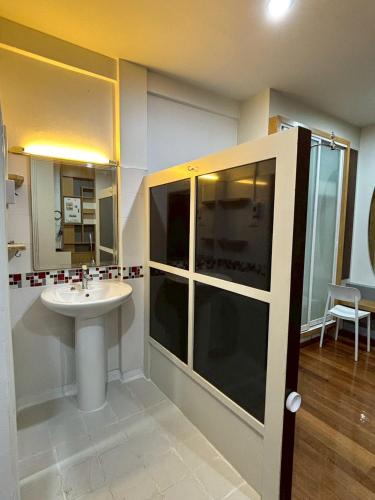 a bathroom with a sink and a glass shower at Anchan Home Stay Hatyai in Hat Yai