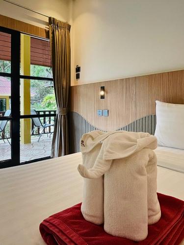 a pile of towels sitting on top of a bed at Tonsai Bay Resort in Tonsai Beach