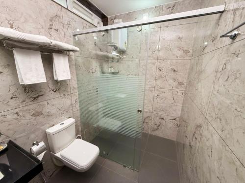 a bathroom with a glass shower with a toilet at Bella Vista Extended Stay in Kalyānpur