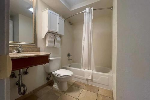 a bathroom with a toilet and a tub and a sink at Baymont Inn & Suites by Wyndham Tempe University/Phoenix in Tempe