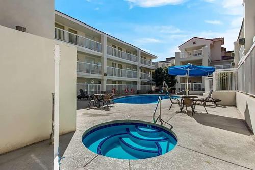 a swimming pool with a table and an umbrella at Howard Johnson by Wyndham Tempe University/Phoenix in Tempe