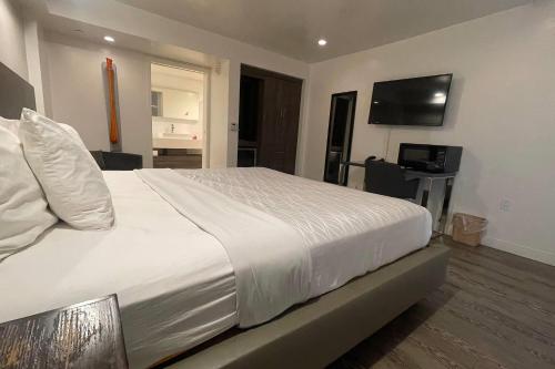 a bedroom with a white bed and a flat screen tv at Howard Johnson by Wyndham Tempe University/Phoenix in Tempe