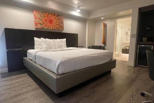 a bedroom with a large bed with a painting on the wall at Howard Johnson by Wyndham Tempe University/Phoenix in Tempe