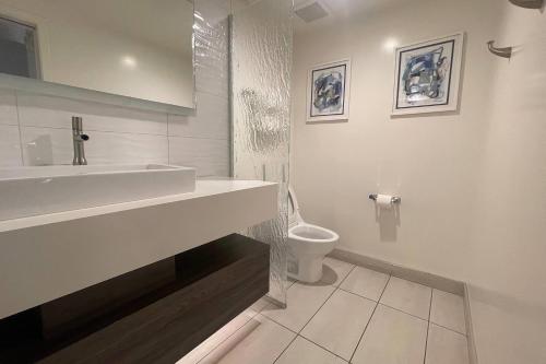 a white bathroom with a sink and a toilet at Howard Johnson by Wyndham Tempe University/Phoenix in Tempe