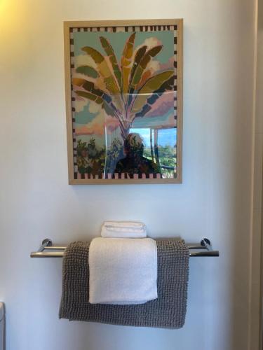 a towel rack in a bathroom with a painting at Corrigans Beach Escape Studio in Batehaven
