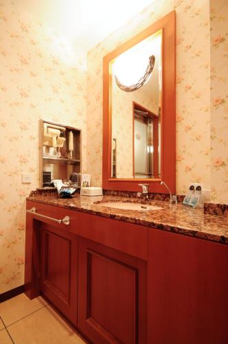a bathroom with a sink and a large mirror at ホテル アイアンプレミアム 六甲店 Adult only男塾ホテルグループ in Kobe