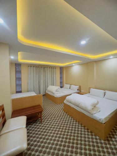a hotel room with two beds and a couch at Shrestha Hotel And Lodge in Dhāding