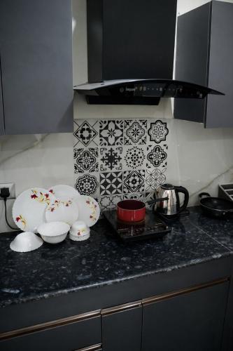 a kitchen counter with bowls and plates on it at Rudra Homestay - Rishikesh in Rishīkesh