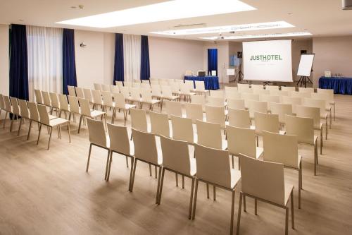 a lecture hall with chairs and a white screen at Just Hotel Lomazzo Fiera in Lomazzo
