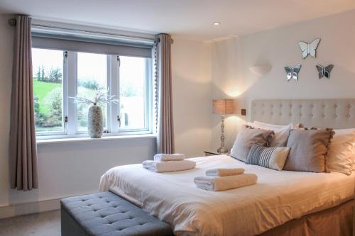 a bedroom with a large bed with towels on it at Estuary View in Kingsbridge