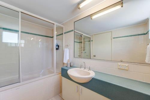 a bathroom with a sink and a tub and a mirror at Seacrest Unit 2 Moffat Beach QLD in Caloundra