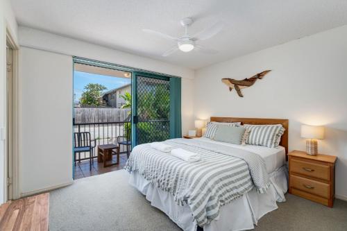 a bedroom with a bed and a balcony at Seacrest Unit 2 Moffat Beach QLD in Caloundra