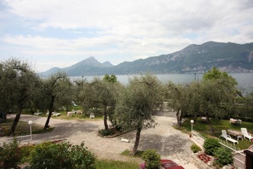 a view of a park with trees and a lake at Hotel Rabay in Brenzone sul Garda