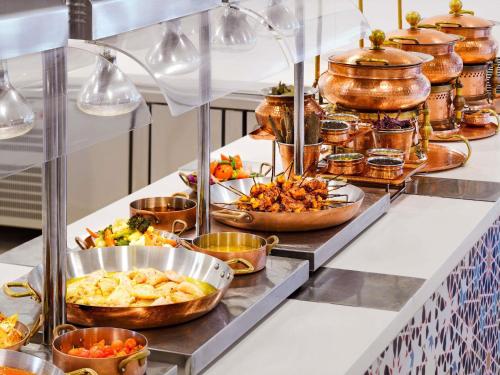 a buffet line with many different types of food at Novotel Dubai Al Barsha in Dubai