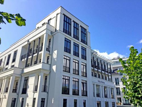 a white building with black windows on top of it at Villa Philine - Meerblicksuite "Carlotta" in Ostseebad Sellin
