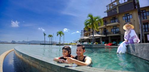 a man and a woman in a swimming pool at Resorts World Langkawi in Pantai Cenang