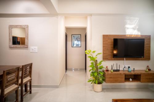 a living room with a flat screen tv on a wall at Luho Aarambha in Bangalore