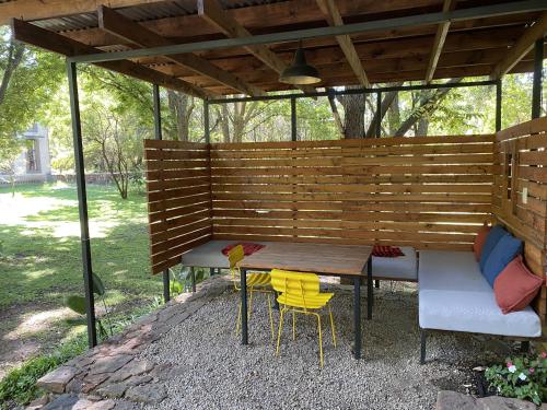a picnic table and chairs under a wooden pergola at Porcupine House in Magaliesburg