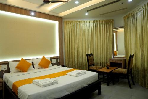 a hotel room with a bed and a table and chairs at KRISHNA HOLIDAY VILLAGE in Trichūr