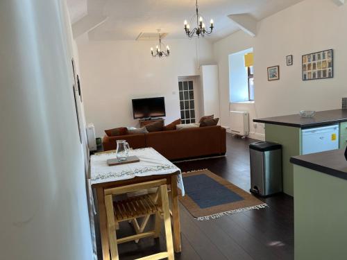 a kitchen and living room with a couch and a table at Large town flat 2 minutes from Pembroke Castle in Pembroke