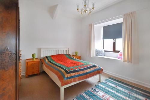 a bedroom with a bed and a window and a rug at Large town flat 2 minutes from Pembroke Castle in Pembroke