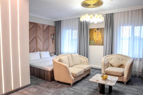 a hotel room with a bed and a chair at Infinity Plaza Hotel Block 2 in Atyrau