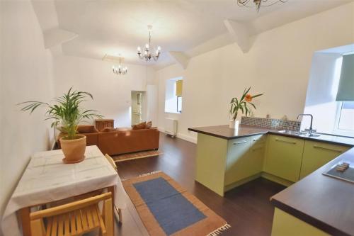 a kitchen and living room with a table and a couch at Large town flat 2 minutes from Pembroke Castle in Pembroke