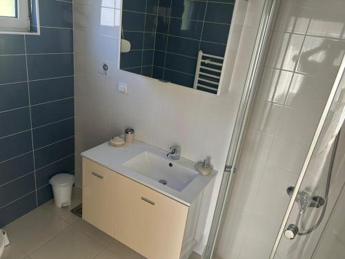 a bathroom with a sink and a shower with a mirror at Bright house in Bar