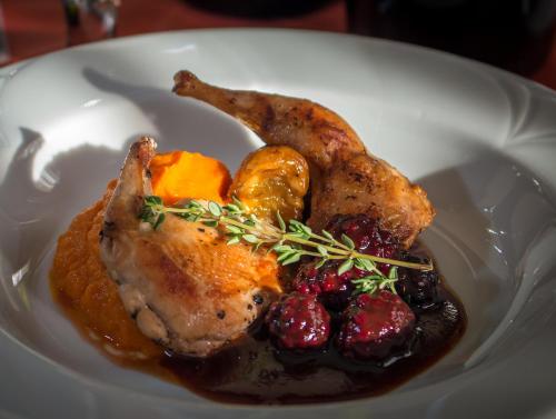 a plate of food with chickens and fruit on it at Platan Hotel in Debrecen