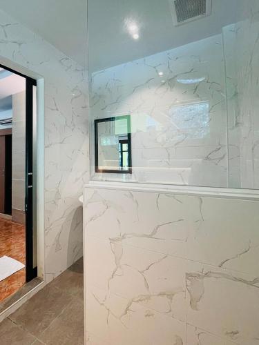a bathroom with white marble walls and a mirror at Tonsai Bay Resort in Tonsai Beach