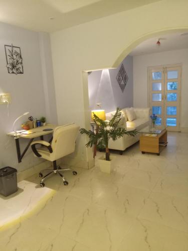 a living room with a couch and a desk and a chair at Beautiful 1-bed Apartment-Suite Kolkata near Airport in Kolkata