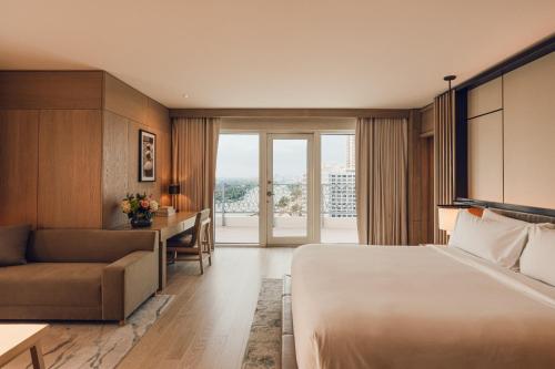 a hotel room with a bed and a desk and a couch at Nobu Hotel Miami Beach in Miami Beach