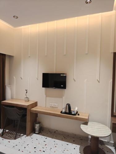 a room with a desk and a tv on a wall at Hotel Natraj Sirsa in Sirsa