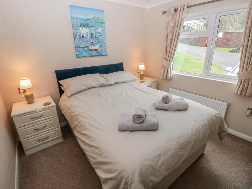 a bedroom with a bed with towels on it at Dono's Lodge in Narberth