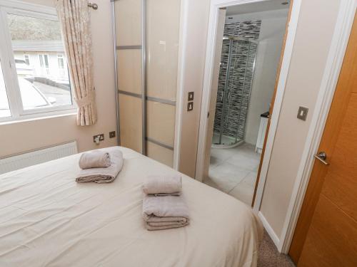 a bedroom with a bed with two towels on it at Dono's Lodge in Narberth