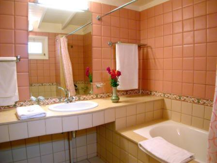 een badkamer met een wastafel, een bad en een spiegel bij Hotel Moulay Yacoub in Moulay Yacoub