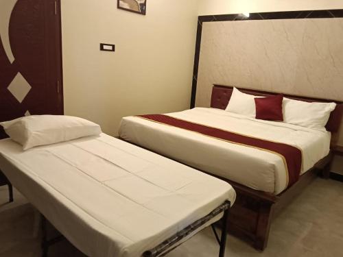 two beds in a hotel room withskirts at Tamil Homestay in Thanjāvūr