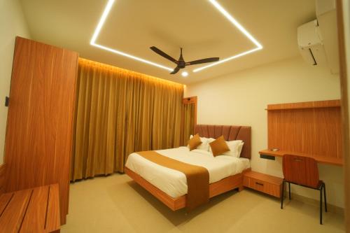 a bedroom with a bed and a ceiling fan at Arunaragha in Mysore