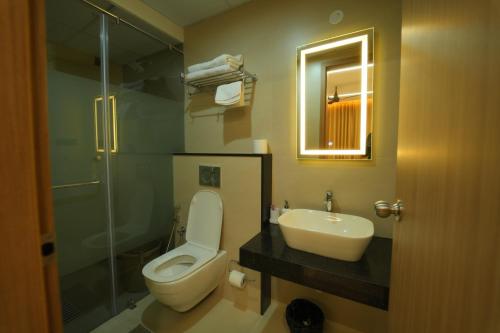a bathroom with a toilet and a sink and a shower at Arunaragha in Mysore