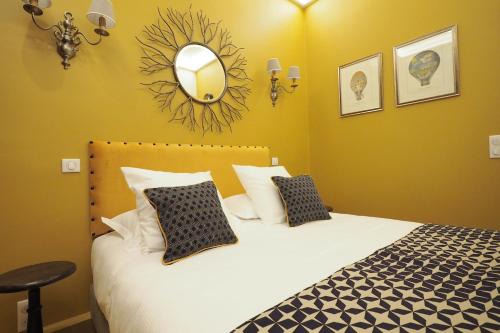 une chambre avec un lit avec un miroir au mur dans l'établissement Louvre Opera Private ChicSuites, à Paris