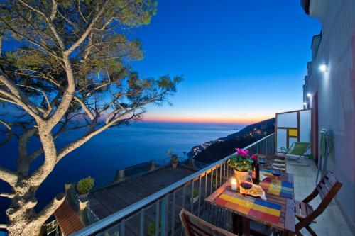 a balcony with a table and a view of the ocean at Calipso Residence in Furore