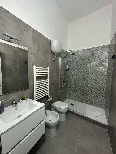 a bathroom with a white sink and a toilet and a tub at Dimora del Corso in Caserta