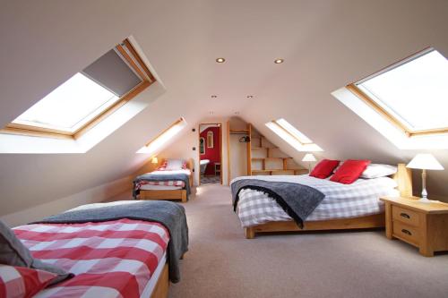 a attic bedroom with two beds and skylights at Gadlas in Sarn
