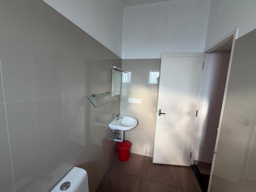 a white bathroom with a sink and a toilet at Hotel serenity in Cochin