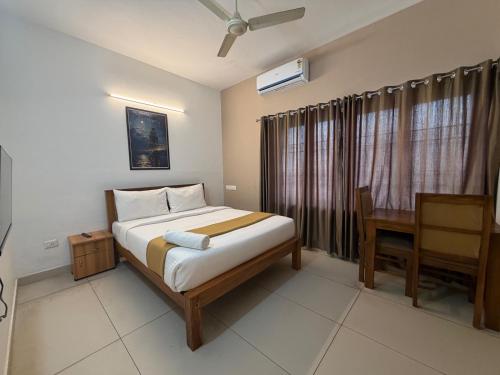 a bedroom with a bed and a desk and a bed sidx sidx sidx at Hotel serenity in Cochin