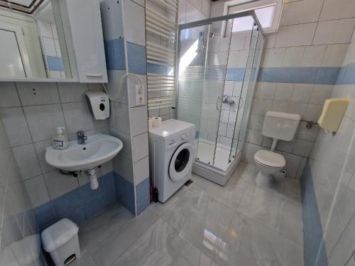 a bathroom with a toilet sink and a washing machine at Studio Apartman Grgurić in Karlovac
