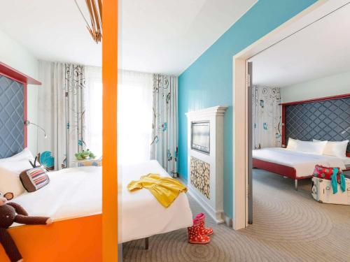 a bedroom with two beds and a mirror at ibis Styles Hotel Berlin Mitte in Berlin