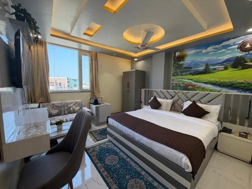 a bedroom with a bed and a desk and a couch at Hotel Aveda Paradise in Varanasi